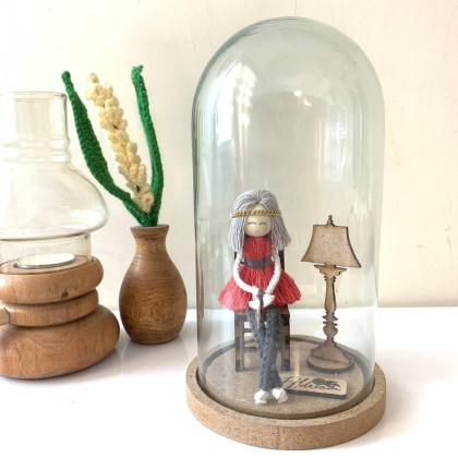 عروسک مکرومه‌ای داخل شیشه نشسته